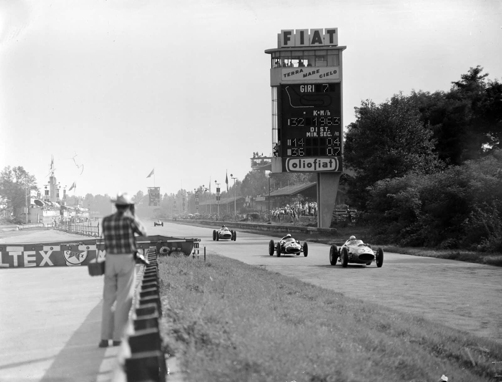 Phil Hill, in a Ferrari 246, leads Stirling Moss driving a Cooper T51 Climax and Dan Gurney also in a Ferrari 246