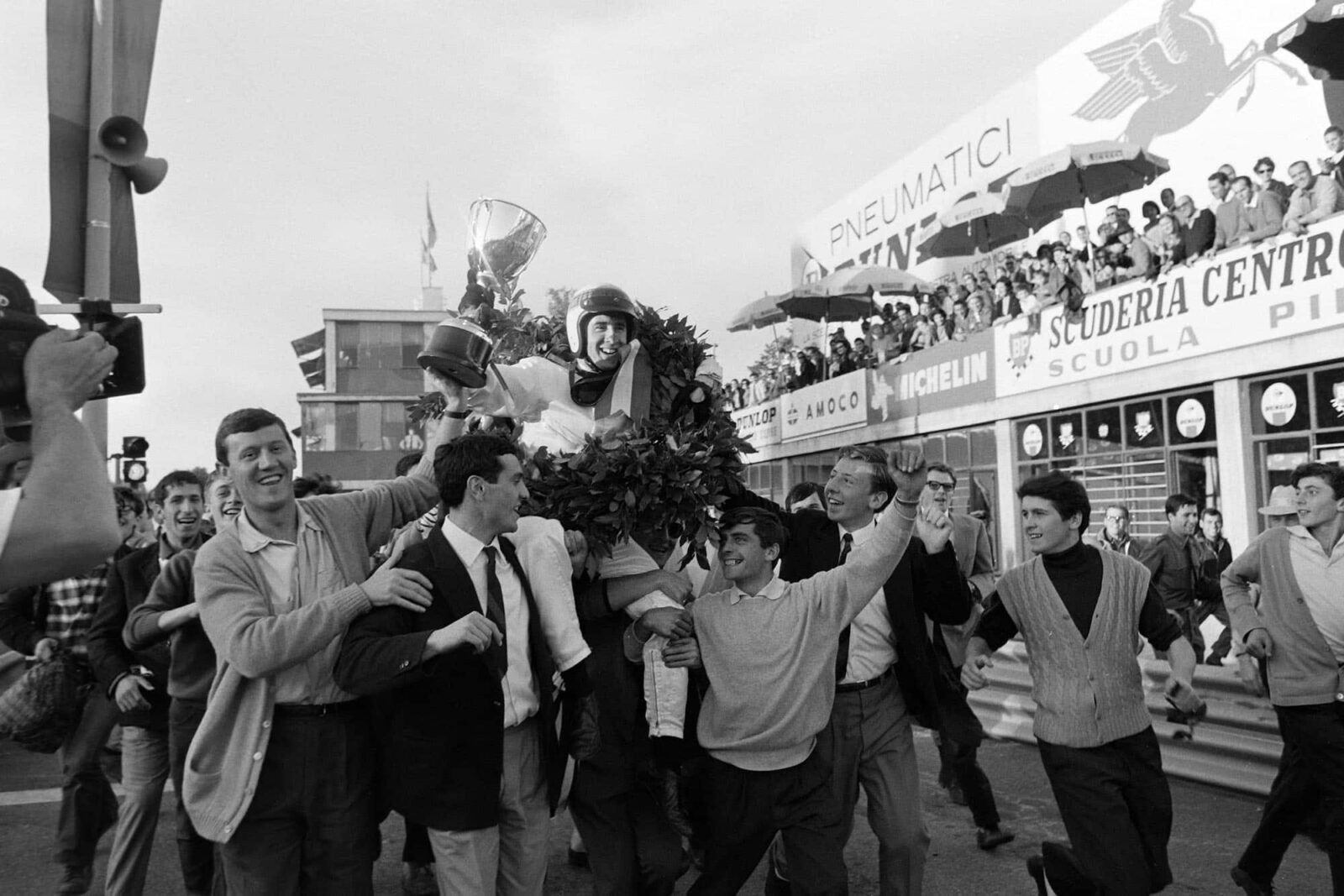 Race winner Jackie Stewart is carried through the pit lane after the podium celebration.