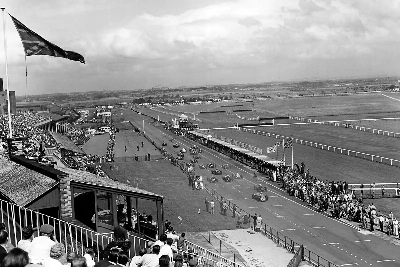 Stirling Moss in the BRM P25 passes Bruce McLaren in his Cooper-Climax T45.