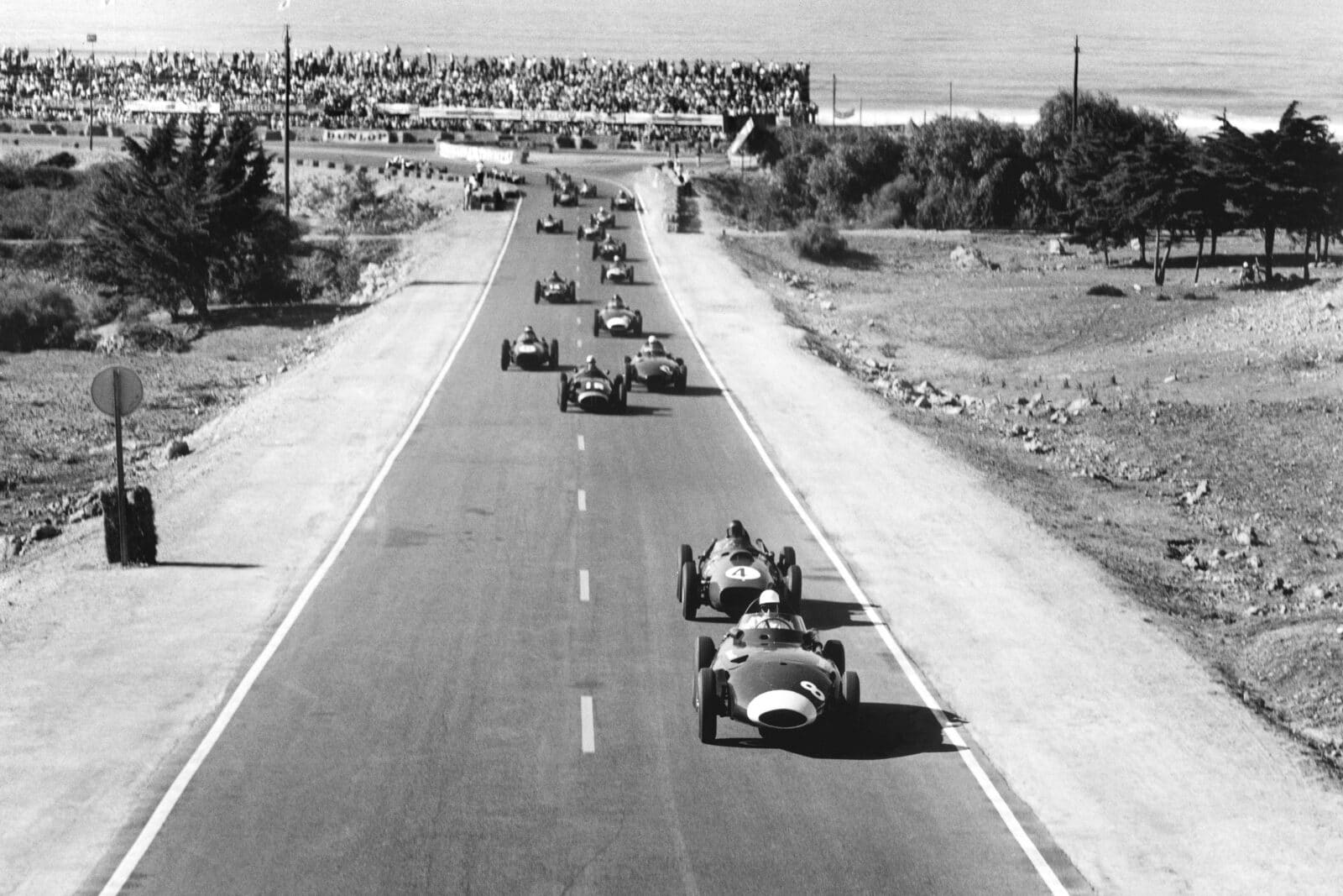 Stirling Moss driving a Vanwall VW5 leads Phil Hill in a Ferrari Dino 246 at the start of the race.