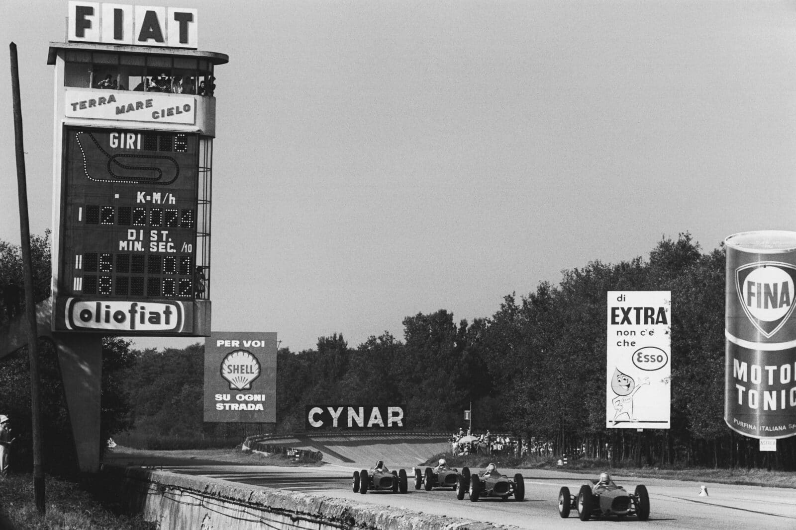Four Ferrari Dino's 156 race down the main straight.