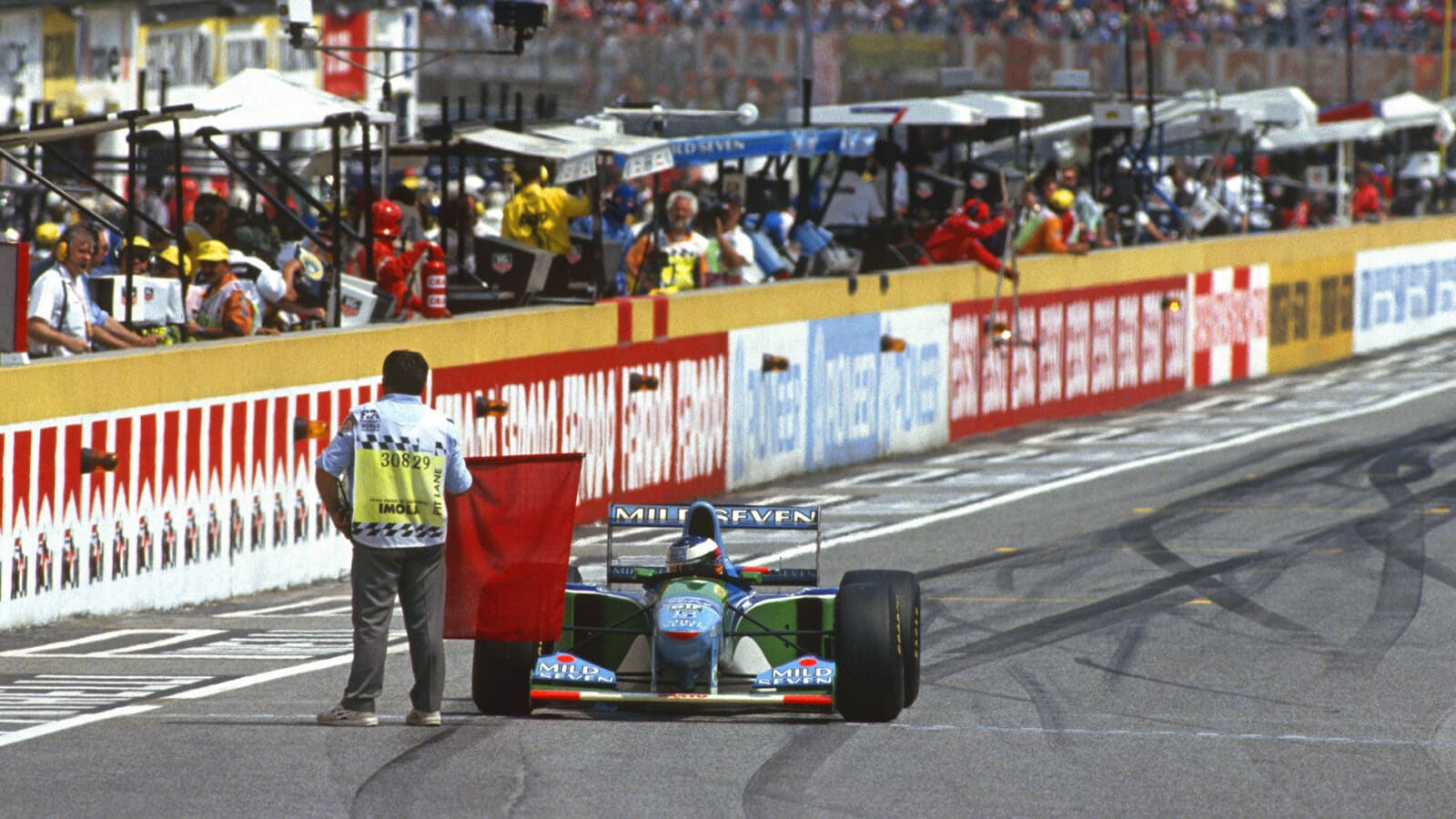 Steward holds red flag in front of Michael Schumacher Benetton at the 1994 San Marino Grand Prix