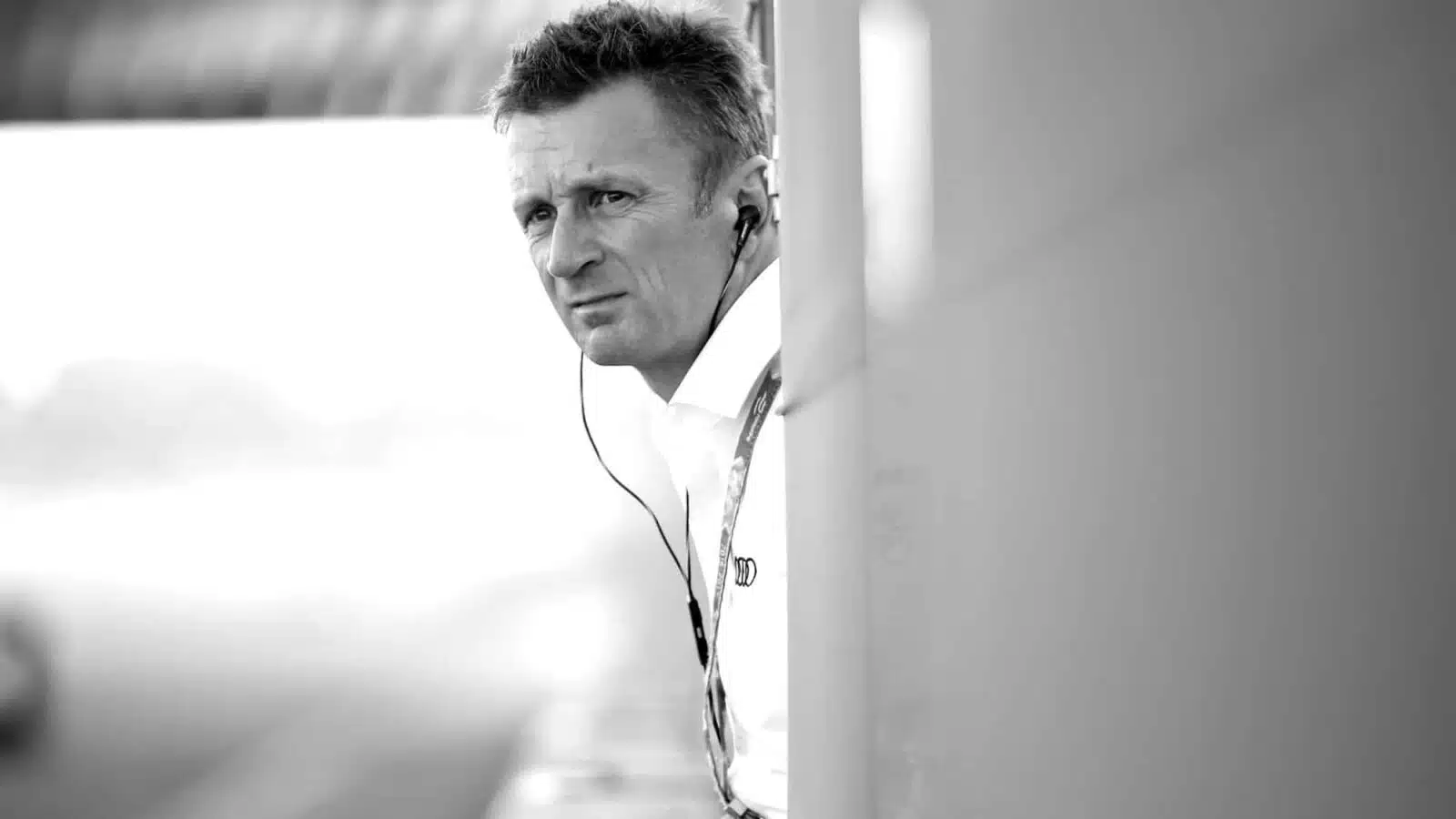 Allan McNish leans over to the track from a pitlane