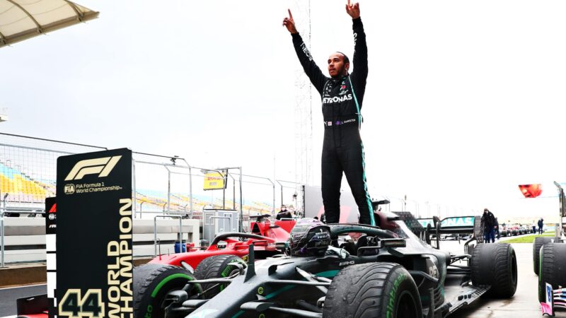 Lewis Hamilton raises his arms in the air as he celebrates winning the 2020 F! World Championship and the Turkish Grand Prix
