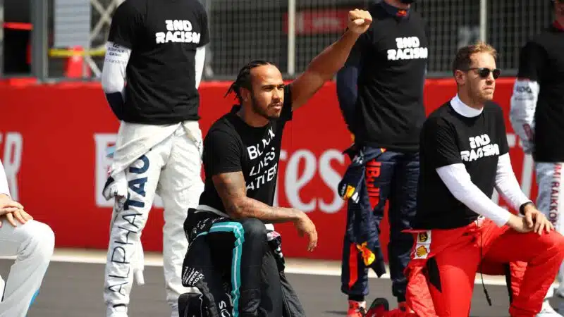 NORTHAMPTON, ENGLAND - AUGUST 09: Lewis Hamilton of Great Britain and Mercedes GP takes a knee on the grid in support of the Black Lives Matter movement prior to the F1 70th Anniversary Grand Prix at Silverstone on August 09, 2020 in Northampton, England. (Photo by Bryn Lennon/Getty Images)