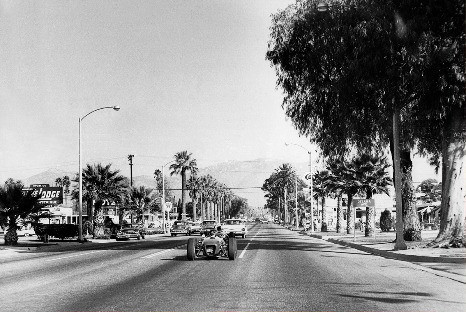 Jim Clark and John Surtees drive Lotus 18s through the streets of California