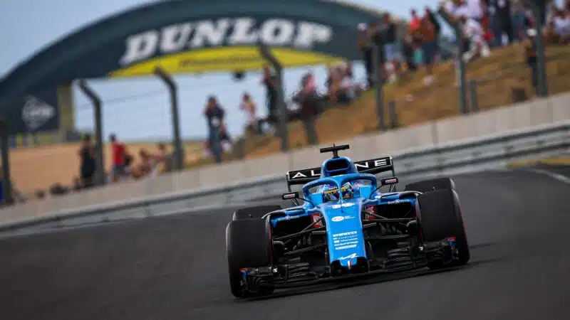 Fernando Alonso in Alpine F1 car in front of Le Mans Dunlop bridge