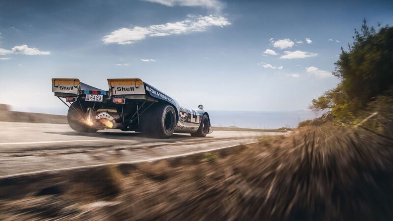 Flames shoot from the exhaust of a Porsche 917-037