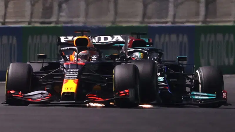 JEDDAH, SAUDI ARABIA - DECEMBER 05: Max Verstappen of the Netherlands driving the (33) Red Bull Racing RB16B Honda and Lewis Hamilton of Great Britain driving the (44) Mercedes AMG Petronas F1 Team Mercedes W12 collide during the F1 Grand Prix of Saudi Arabia at Jeddah Corniche Circuit on December 05, 2021 in Jeddah, Saudi Arabia. (Photo by Lars Baron/Getty Images)
