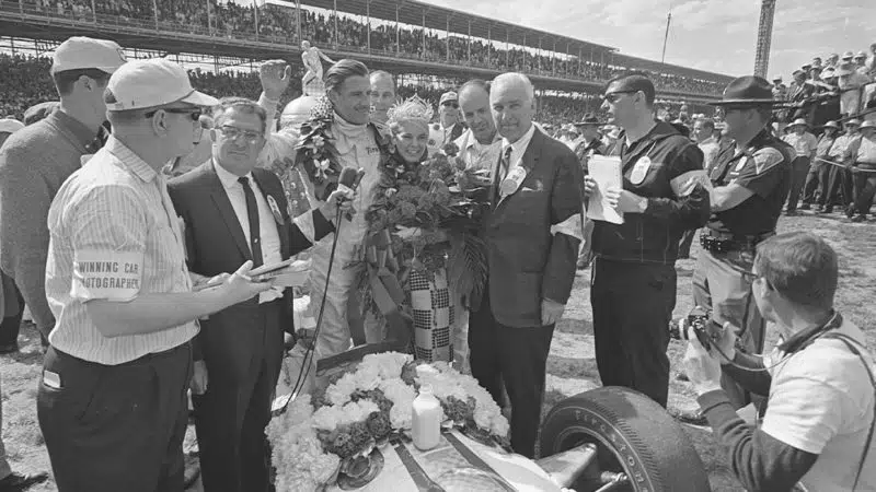 1966: Graham Hill celebrates victory in the Indianapolis 500 motor race driving a Lola car. The trophy can just be seen rising behind him. Mandatory Credit: Allsport Hulton/Archive