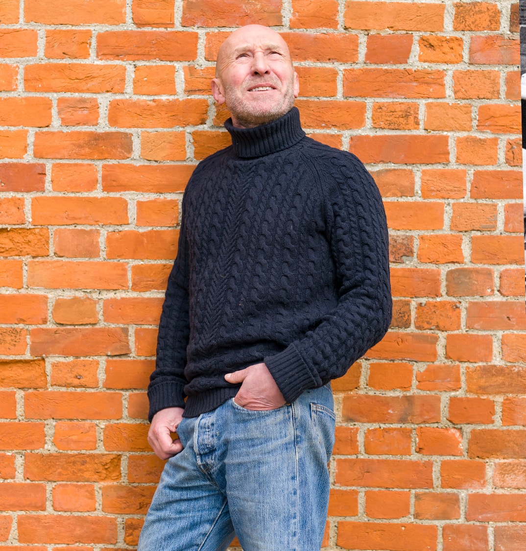 Perry McCarthy against brick wall