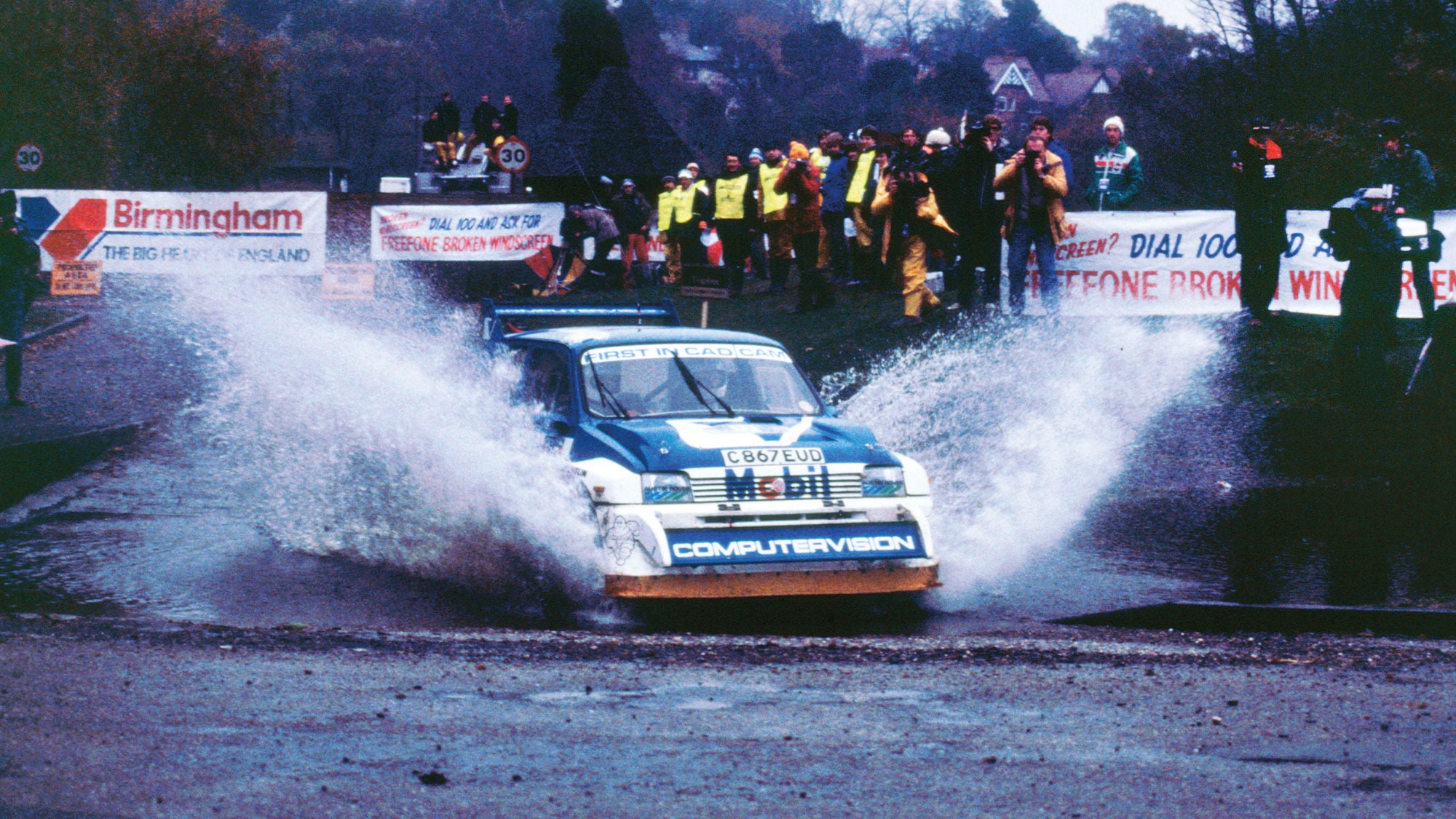 Metro 6R4 rally car splashes through large puddle