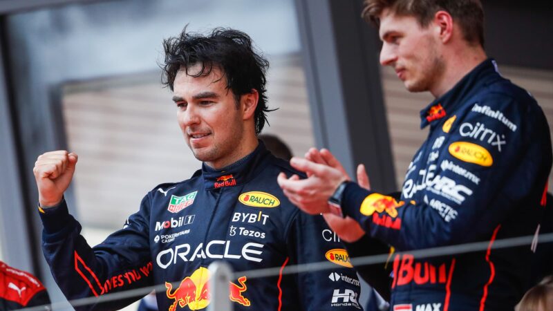 Sergio Perez pumps his fist on the podium nbext to Max Verstappen at the 2022 Monaco Grand Prix