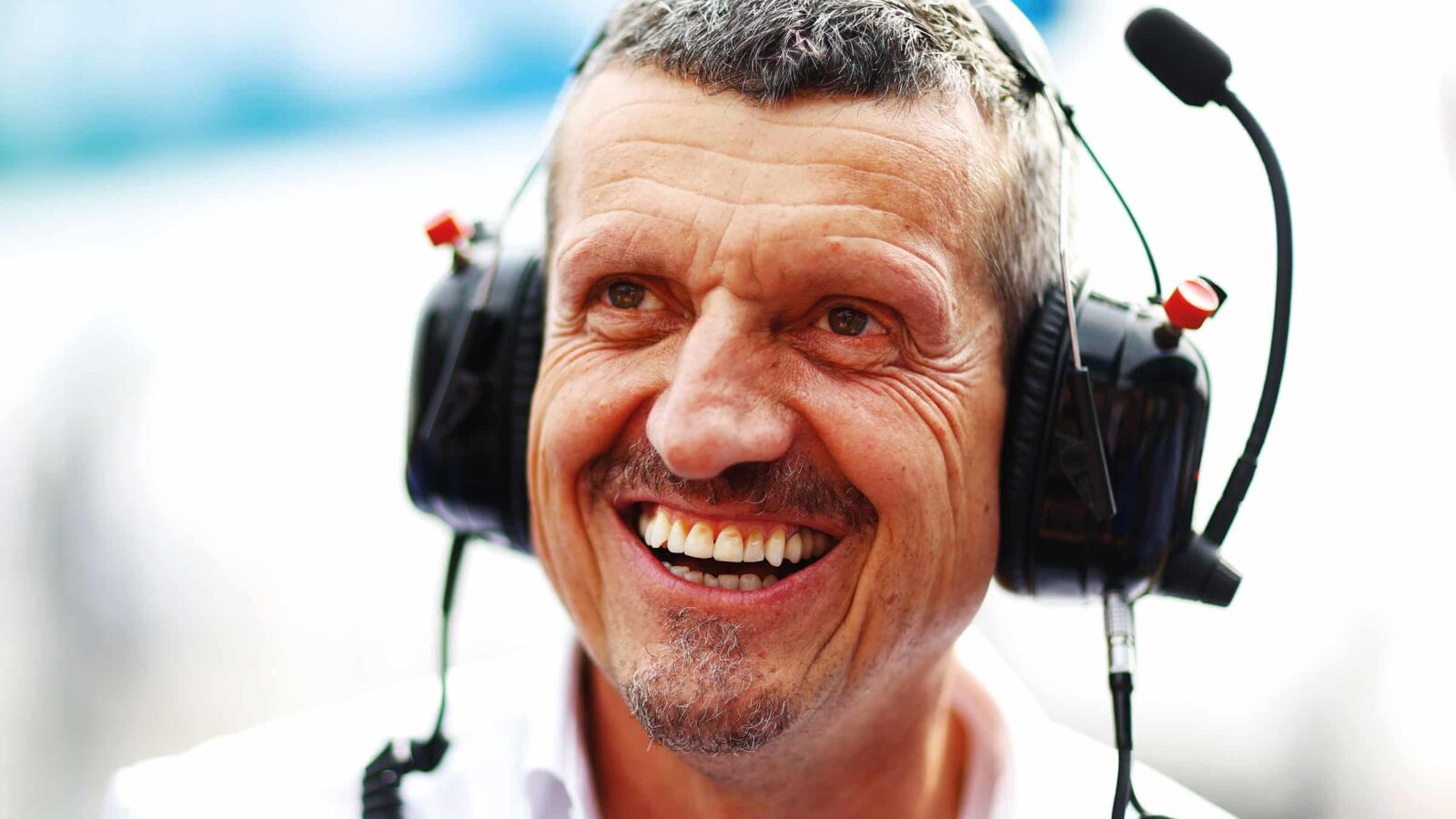 Guenther Steiner smiles in headphones