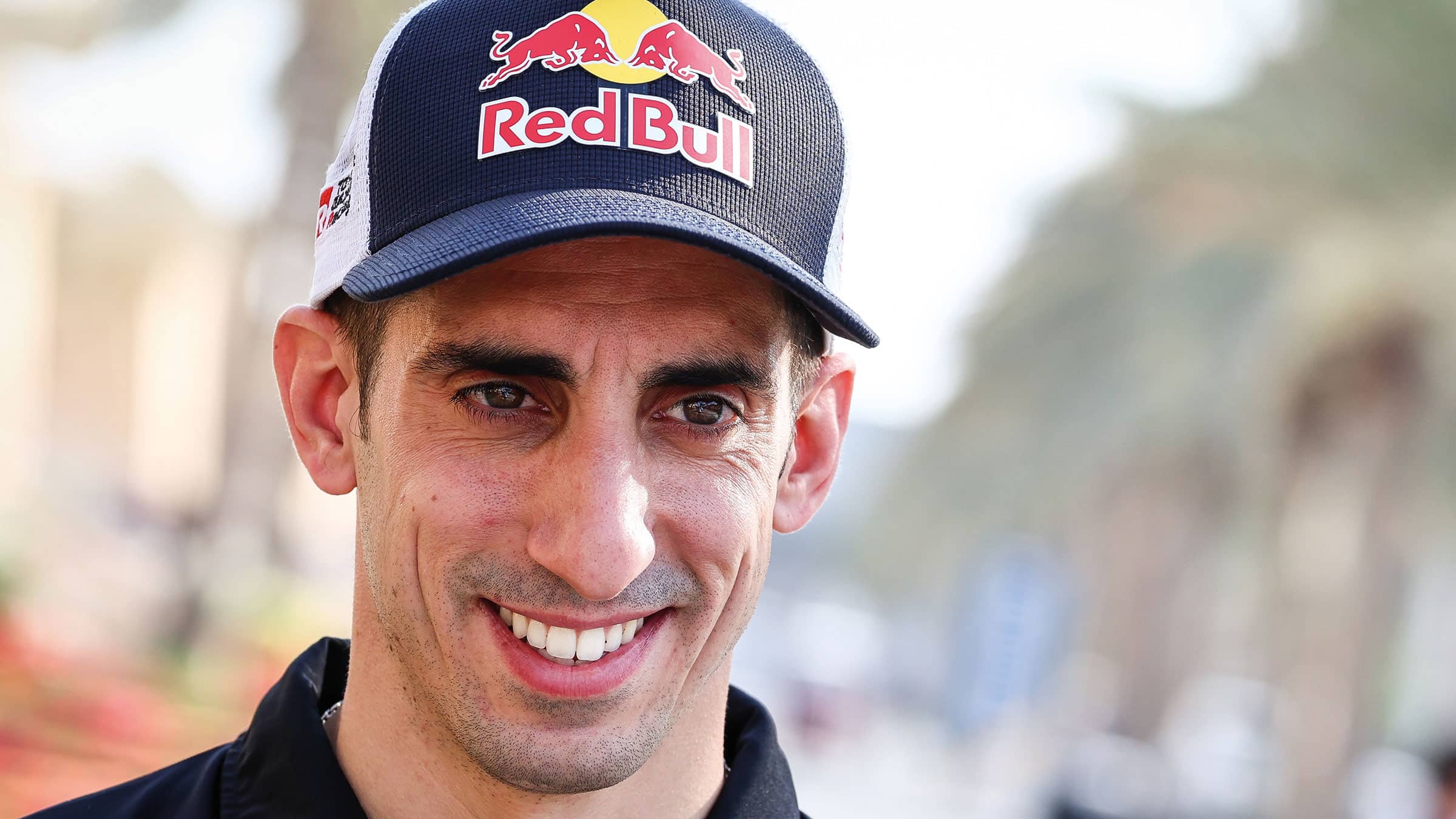 Sébastien Buemi smiling in red bull cap