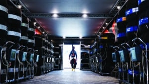 Sergio Perez walks between stacks of tyres