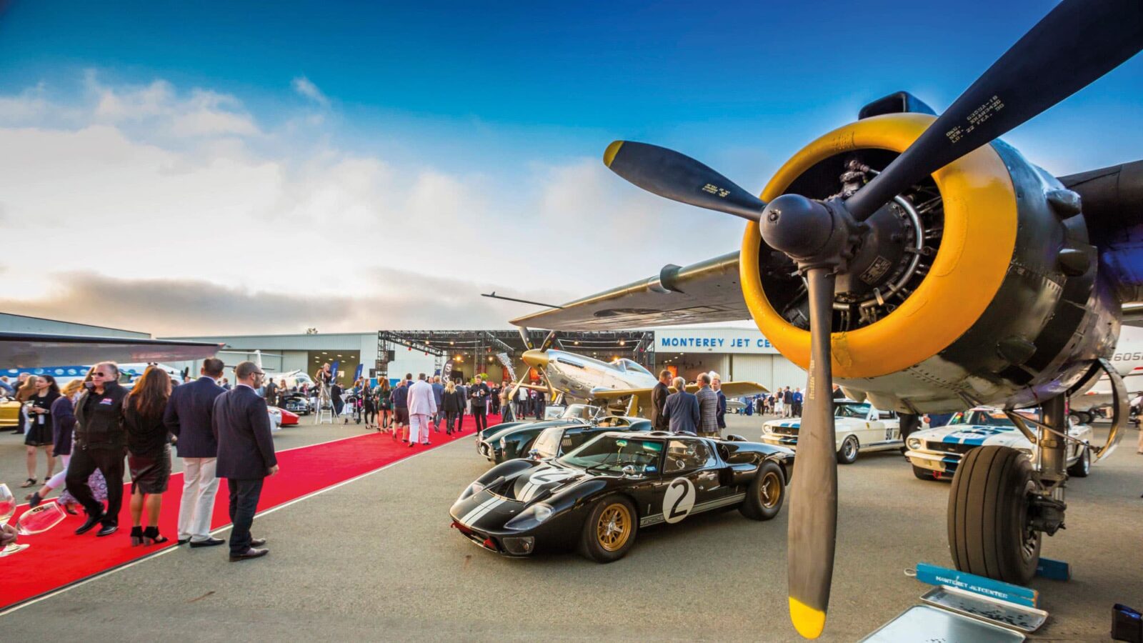 Classic cars parked with planes at Monterey