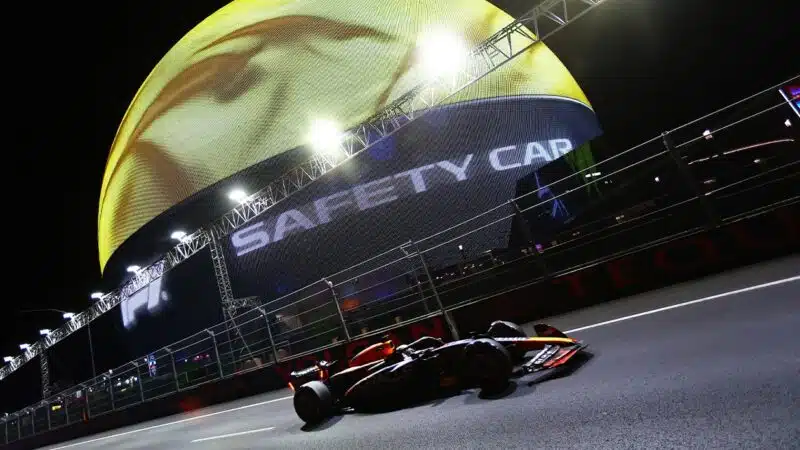 Red Bull of Max Verstappen with broken front wing in front of Las Vegas sphere displaying safety car message