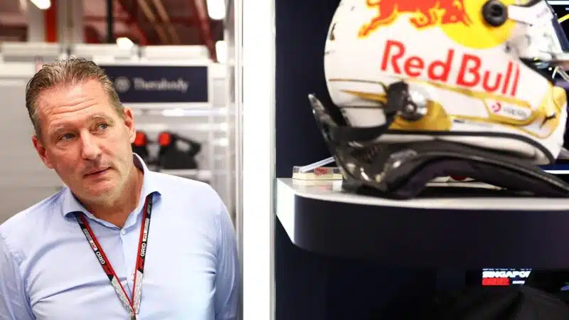 Jos Verstappen looks at Max Verstappen helmet in Red Bull F1 pit garage