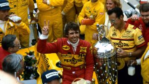 Rick Mears with car and Borg Warner Trophy celebrates winning 1984 Indy 500