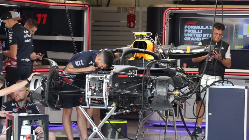 Mechanics work on Red Bull F1 car in pits at 2024 United States GP