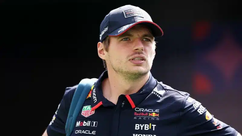 Max Verstappen walks in paddock in Red Bull F1 top