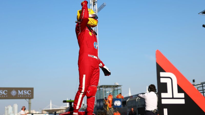 Lewis Hamilton raises his fist while standing on his Ferrari F1 car after claiming pole in 2025 Chinese GP sprint qualifying