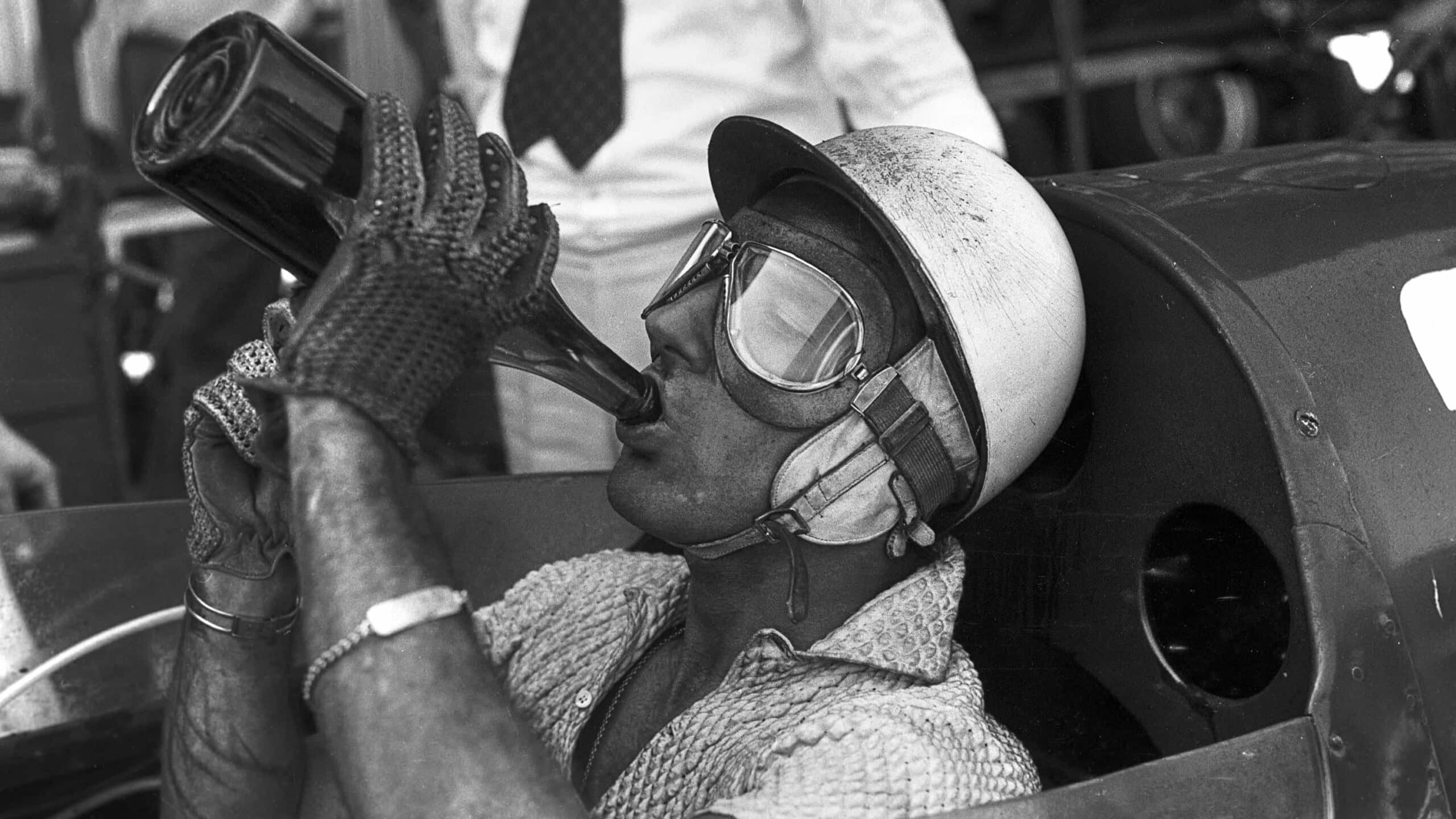 Stirling Moss drinking after race win