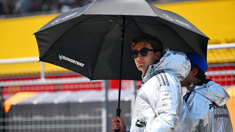 George Russell wearing shiny silver coat and sunglasses in the 2035 F1 Austrian GP drivers parade