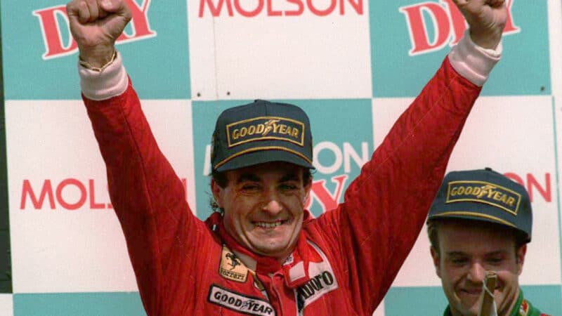 Jean Alesi raises his arms on the F1 podium after winning the 1995 Canadian Grand Prix for Ferrari