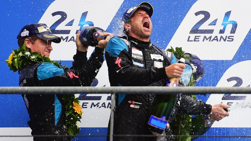 Patrick Dempsey is sprayed with champagne on the podium at the Le Mans 24 Hours
