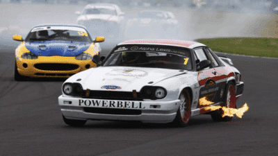 Colin Philpott’s Jaguar XJS spits flame as he races to a podium third at the Castle Combe Classic Sports Car Club meet