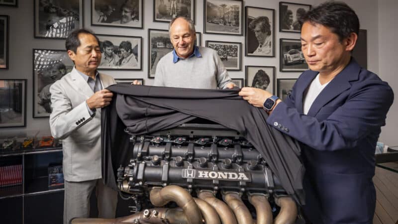 Former F1 driver Gerhard Berger poses with Mr Tanabe and Mr Watanabe of Honda Racing Corporation Japan during the handover of a V12 cylinder Honda RA122E/B engine