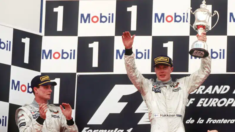 David Coulthard looks on as McLaren team mate Mika Hakkinen raises the winners trophy after the 1997 European Grand Prix at Jerez