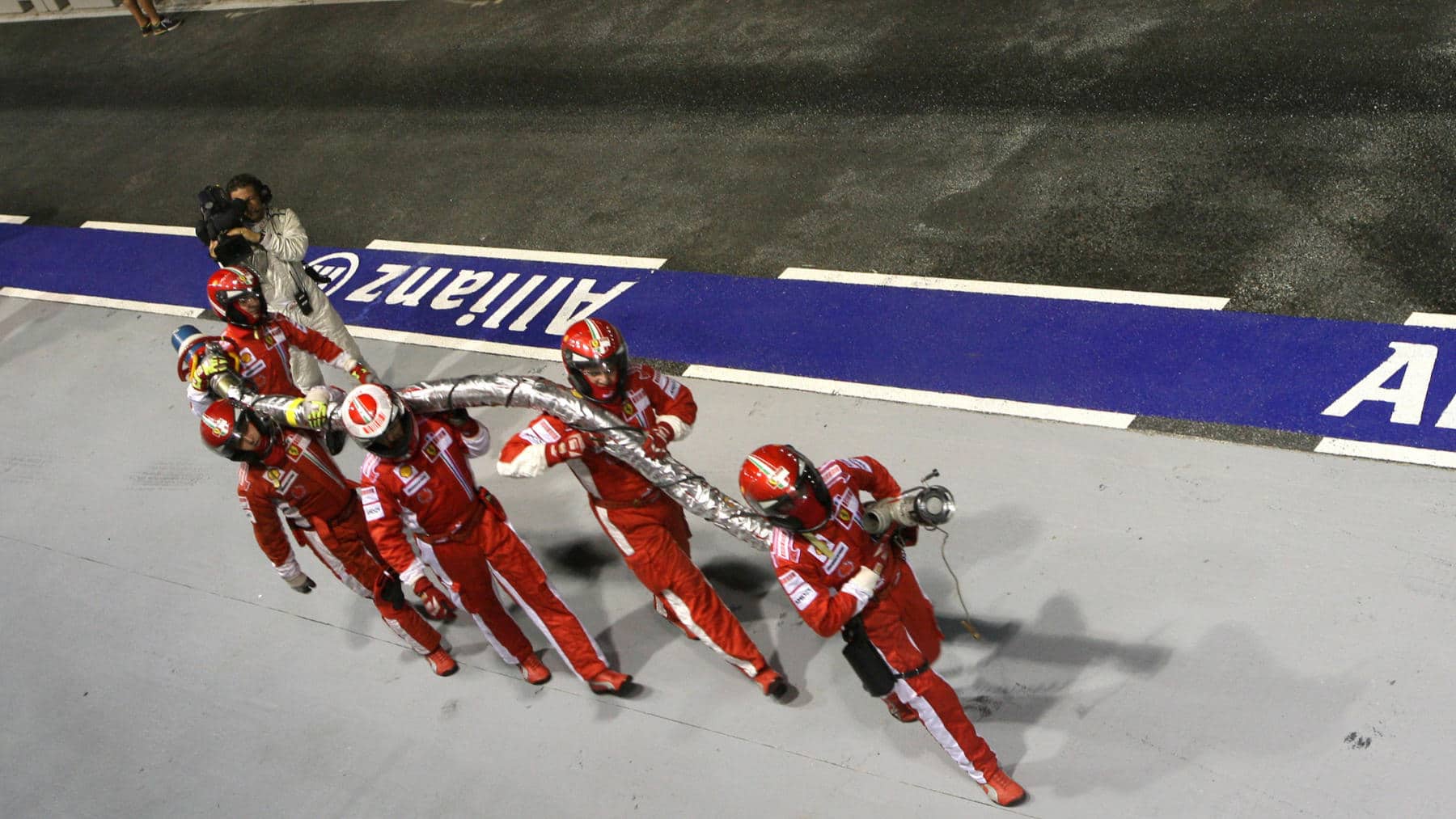 Ferrari mechanics bring back the fuel hose from Felipe Massa´s car during the 2008 Singapore Grand Prix.