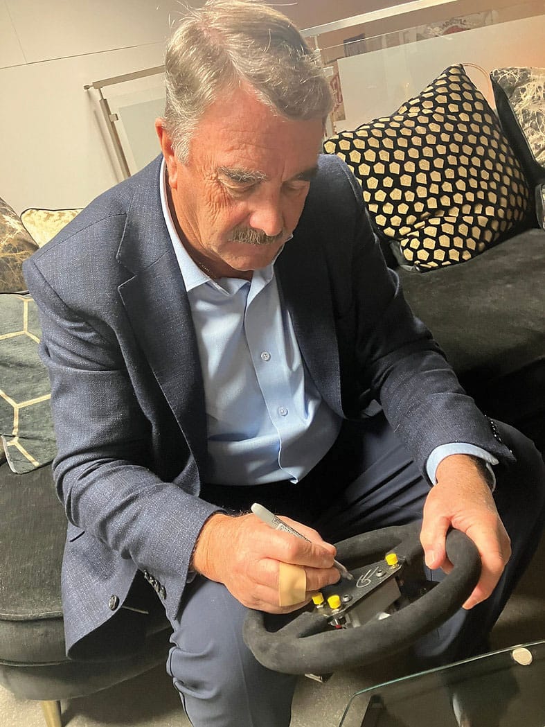 Nigel Mansell signing steering wheel