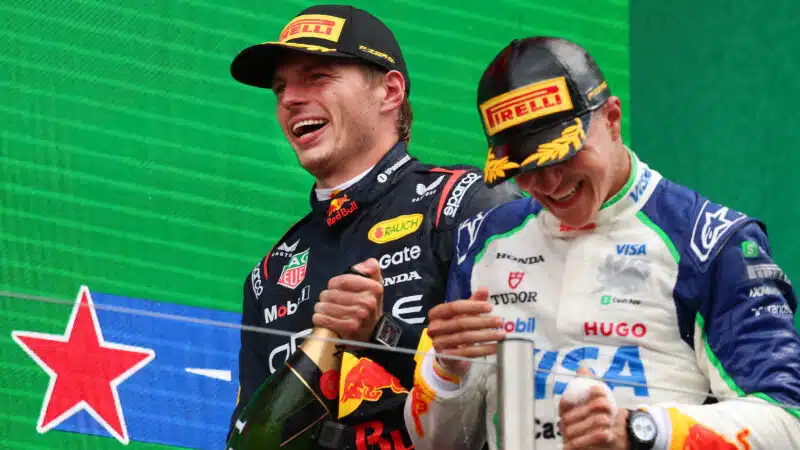 Max Verstappen with Isack Hadjar on podium after 2025 F1 Dutch Grand Prix